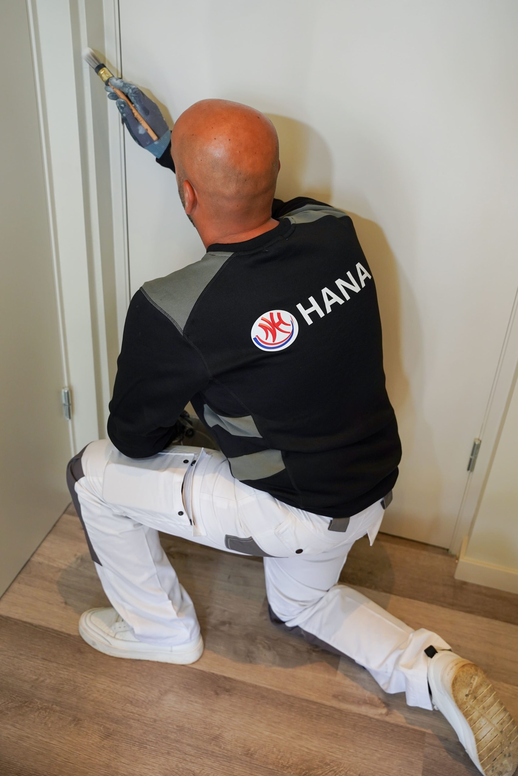 Hana Totaal - Een schilder is bezig met het schilderen van de deurpost foto 2