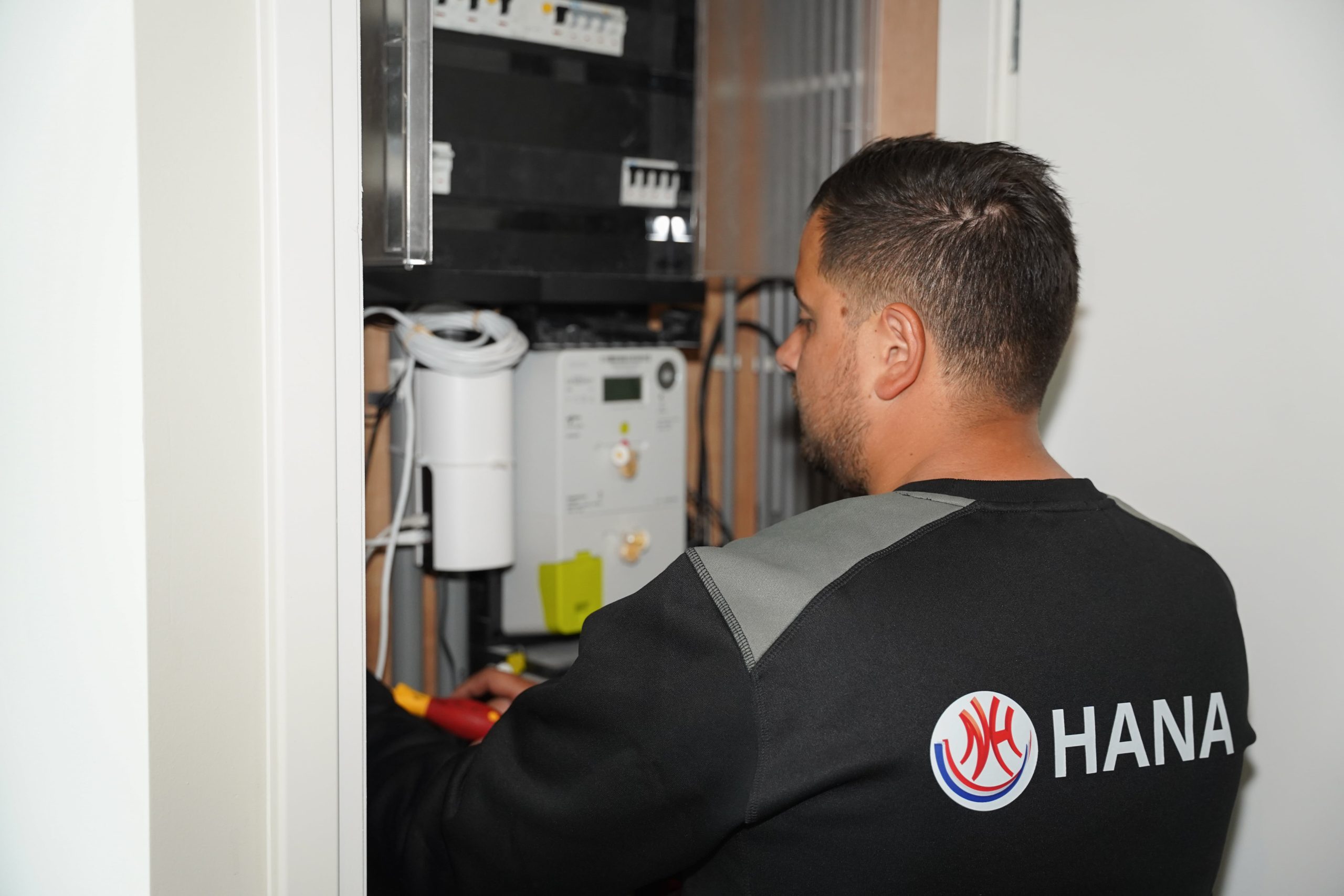 Hana Totaal - Man bezig met werkzaamheden in de meterkast